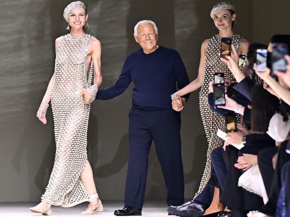 Giorgio Armani celebrating his fashion show in Dubai, showcasing the Armani legacy UAE with models in signature couture designs.